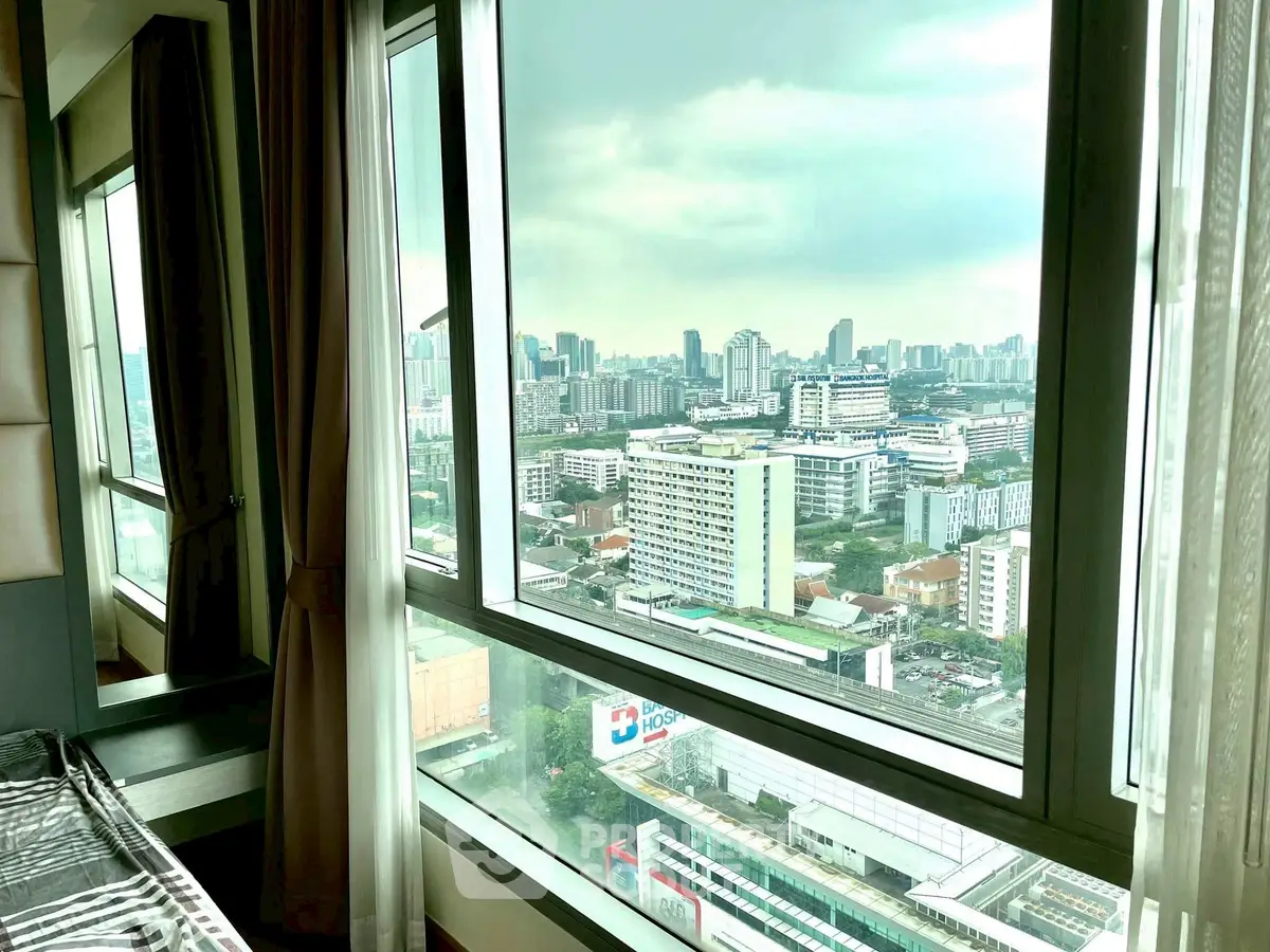 Stunning urban view from high-rise apartment window overlooking city skyline.