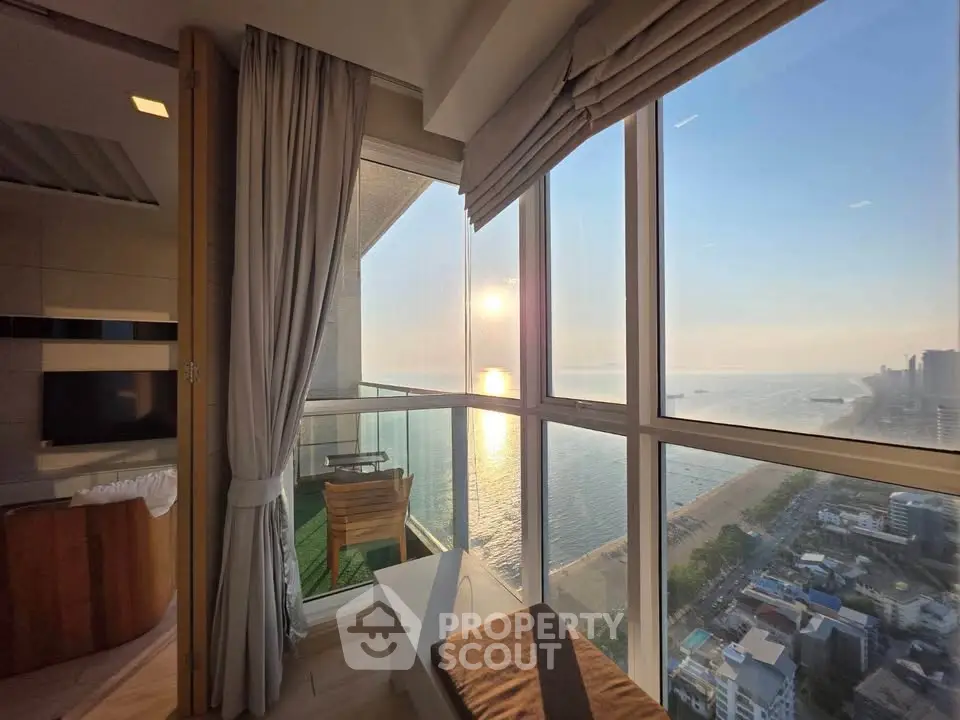 Luxurious high-rise apartment with stunning ocean view and spacious balcony, perfect for sunset relaxation.