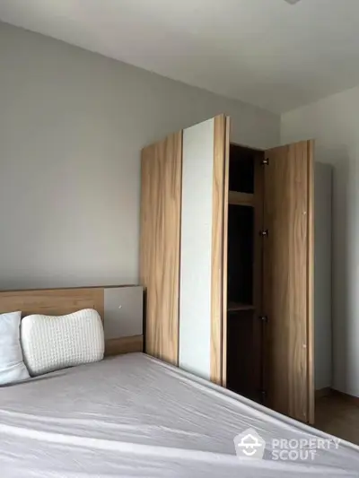 Modern bedroom with wooden wardrobe and cozy bed setup