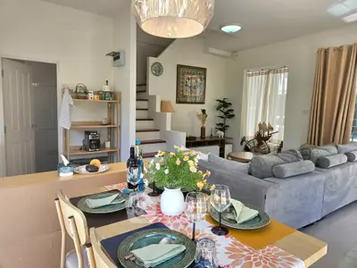 Charming open-plan living and dining area with elegant decor and staircase in modern home.