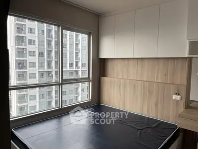 Modern bedroom with large windows and built-in storage in urban apartment