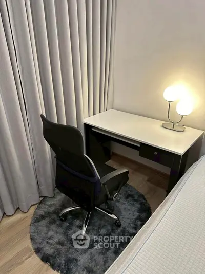 Cozy study nook with modern desk, chair, and stylish lamp in a serene setting.
