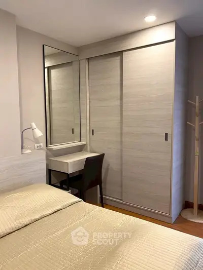 Cozy bedroom with built-in wardrobe and study desk, perfect for modern living.