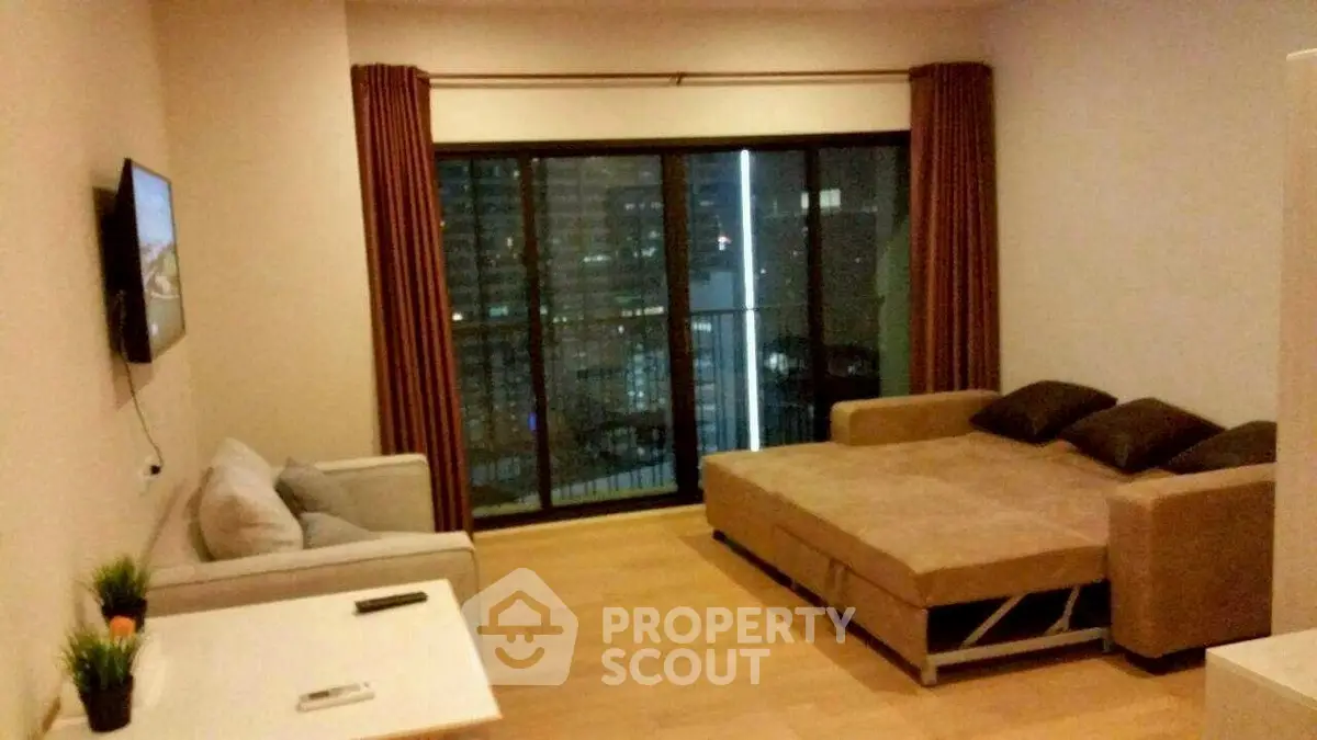 Modern living room with sofa bed and city view balcony, perfect for urban living.