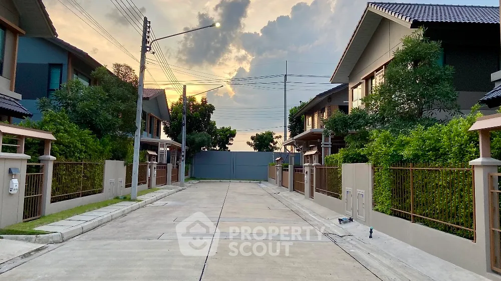 Charming suburban neighborhood with modern houses and lush greenery at sunset.