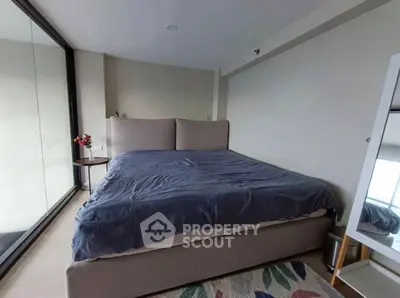 Spacious bedroom with large bed and floor-to-ceiling windows offering natural light.