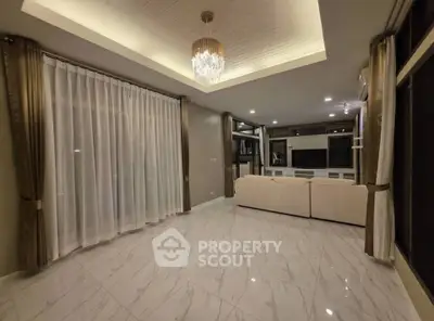 Spacious modern living room with elegant chandelier and large windows