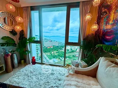 Luxurious living room with stunning city view, elegant decor, and floor-to-ceiling windows.