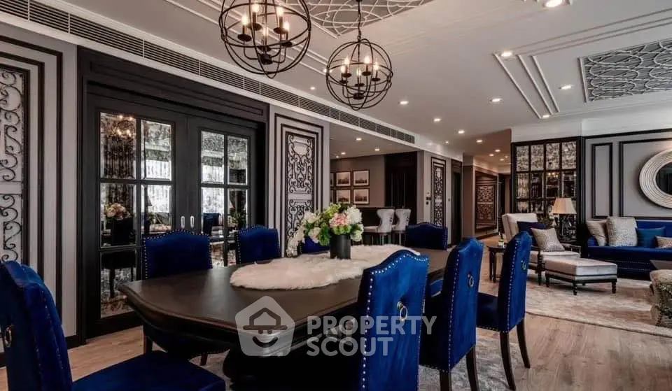 Luxurious dining room with elegant decor and plush blue chairs in a sophisticated apartment.