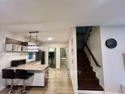 Modern kitchen with open layout and stylish staircase in contemporary home