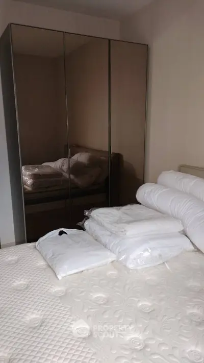 Cozy bedroom with mirrored wardrobe and plush bedding