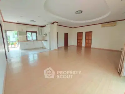 Spacious open-plan living room with kitchen and wooden flooring