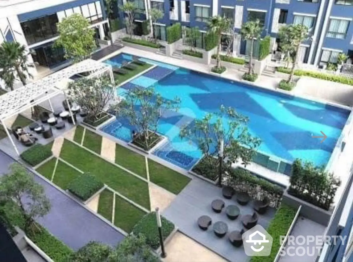 Luxurious modern apartment complex with stunning pool and landscaped garden view.