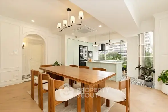 Spacious dining area with wooden table and modern lighting in elegant apartment.