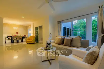 Luxurious living room with elegant dining area and garden view, featuring modern decor and ample natural light.
