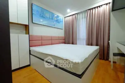 Modern bedroom with stylish decor and large window for natural light.