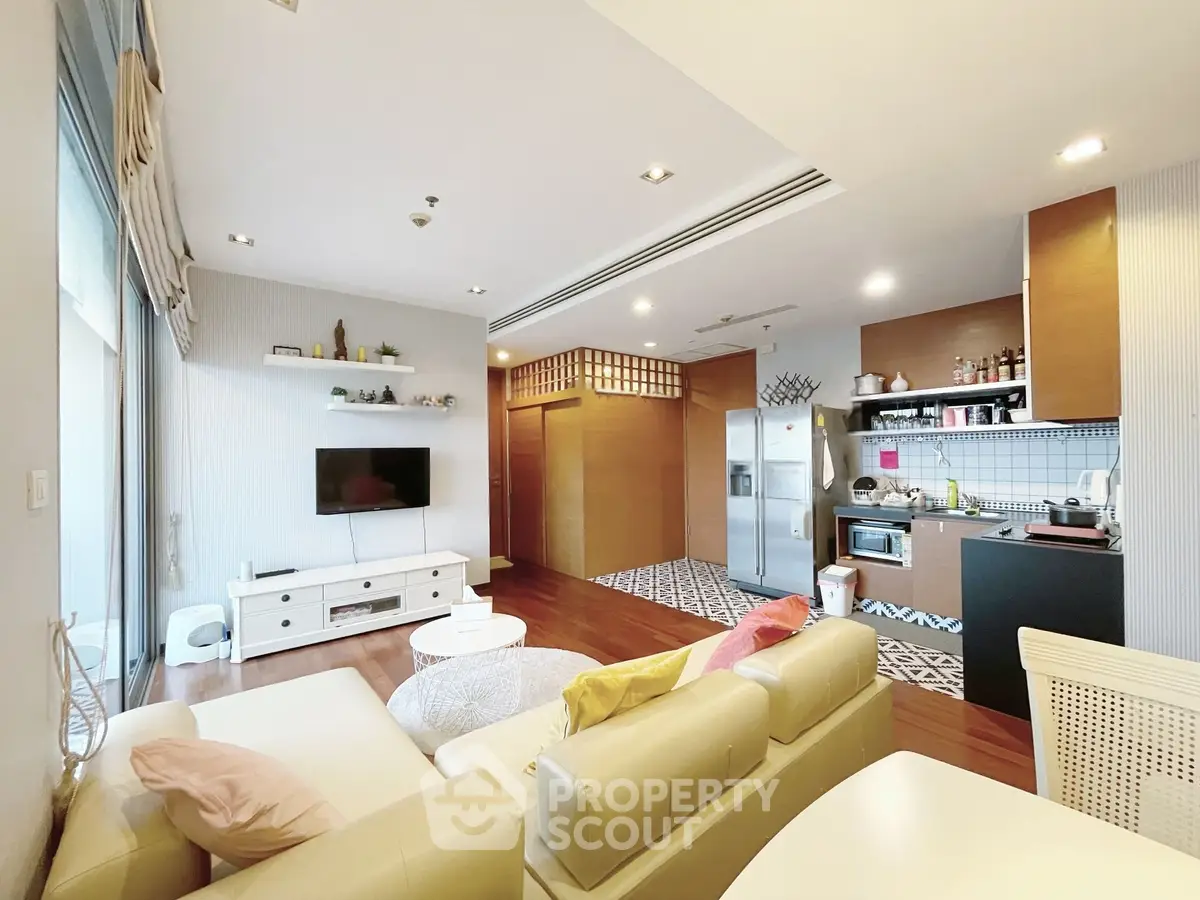 Spacious modern living room with open kitchen, stylish decor, and ample natural light.