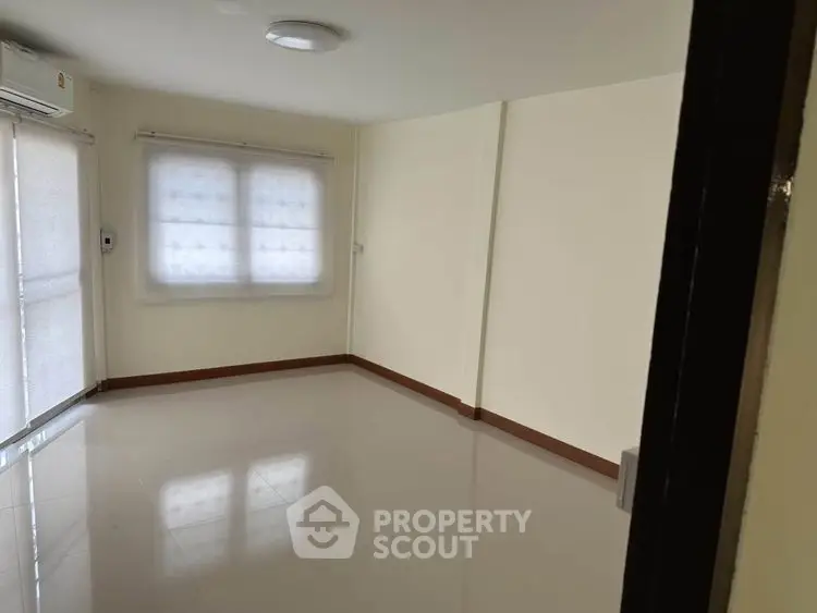 Spacious empty room with large windows and glossy tiled floor, perfect for customization.