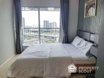 Modern bedroom with city view and large window in high-rise apartment