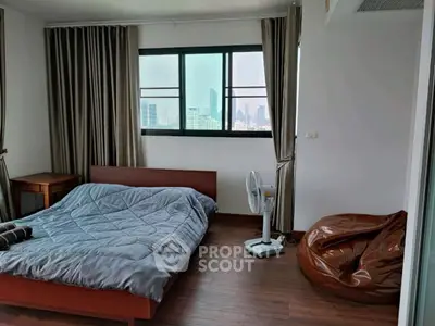 Spacious bedroom with city view, featuring modern decor and cozy furnishings.
