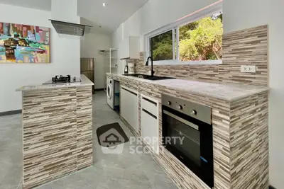 Modern kitchen with sleek appliances and stylish backsplash in a bright, open layout.