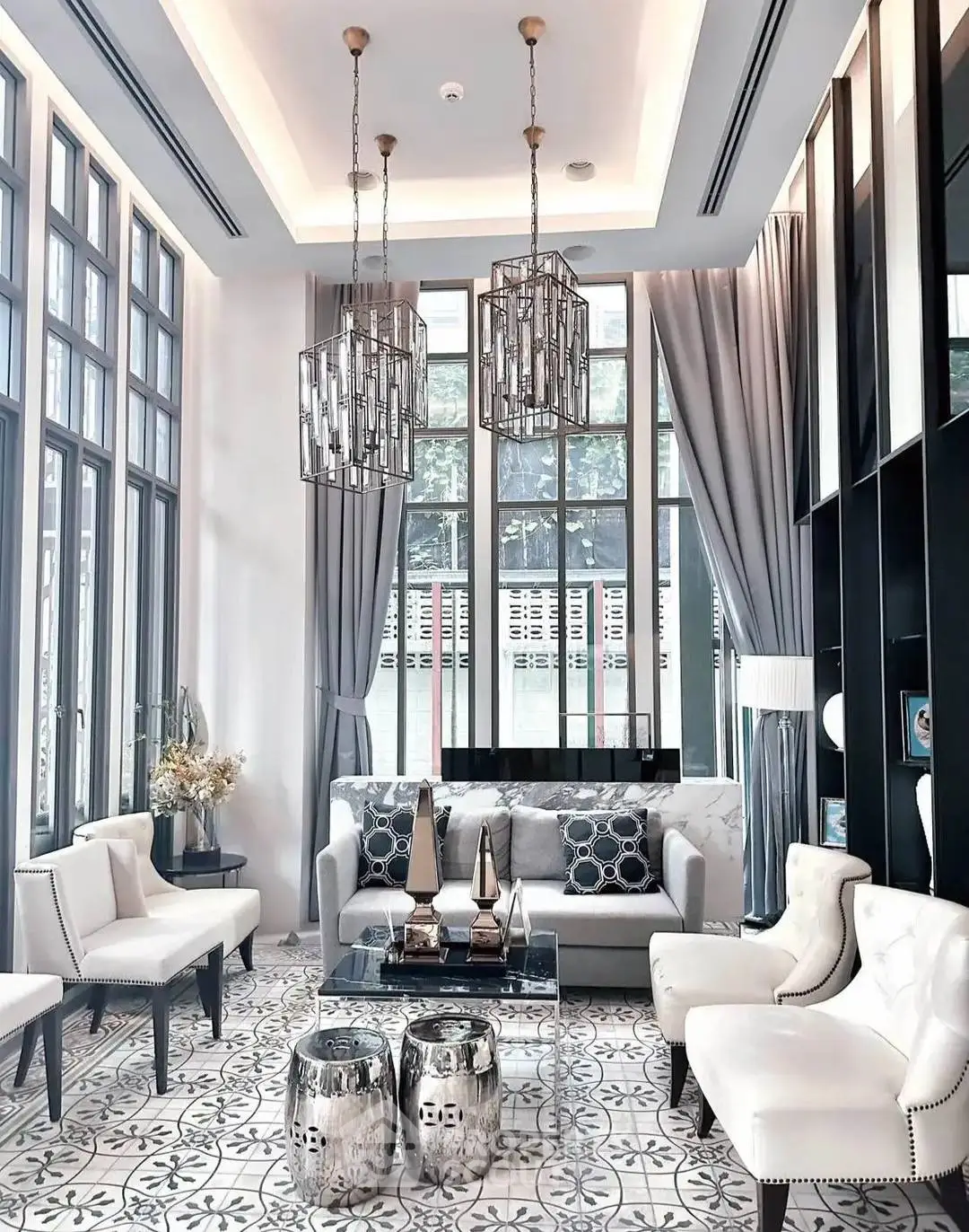 Luxurious high-ceiling living room with elegant decor and large windows