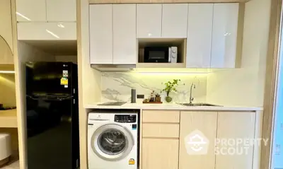 Modern compact kitchen with built-in appliances and sleek cabinetry