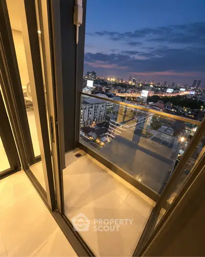 Stunning city view from a modern apartment balcony at dusk, showcasing urban skyline and vibrant city lights.