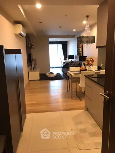 Modern open-plan living room and kitchen with elegant decor and natural light.