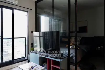 Modern apartment with glass partition, stylish living area, and city view.