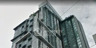 Modern high-rise building with sleek architecture and large windows in urban setting.