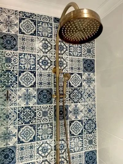 Elegant bathroom with vintage showerhead and intricate blue patterned tiles.