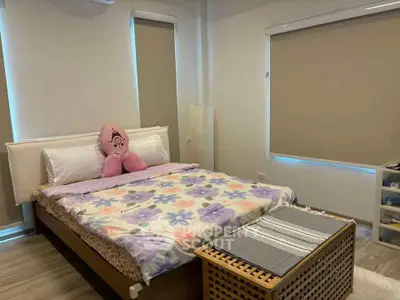 Cozy bedroom with floral bedding and modern decor, perfect for relaxation.