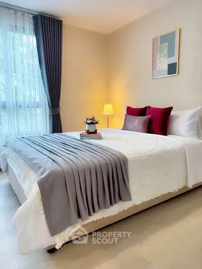 Elegant bedroom with cozy bedding and modern decor, featuring natural light and stylish accents.