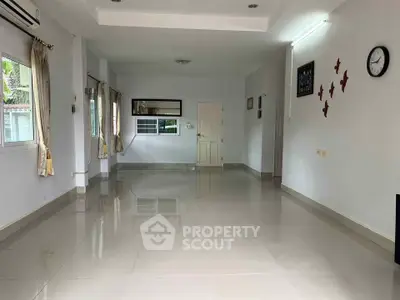 Spacious empty living room with glossy tiled floors and natural light