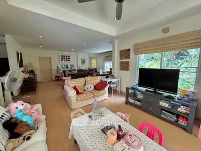 Spacious living room with cozy seating and large windows offering garden views.