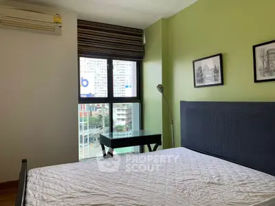 Modern bedroom with green accent wall and city view window