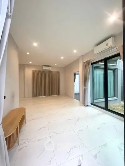 Spacious modern living room with large windows and elegant curtains