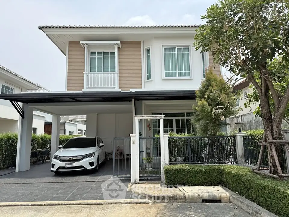 Charming two-story house with carport and lush greenery in a serene neighborhood.