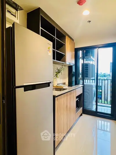 Modern kitchen with sleek appliances and balcony view in urban apartment