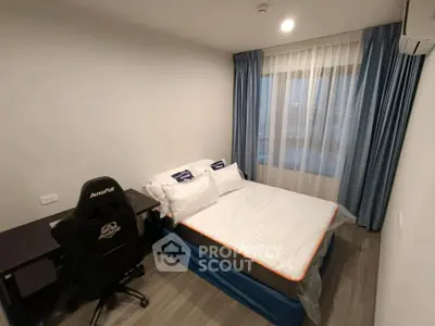 Modern bedroom with gaming chair and large window, perfect for relaxation and work.