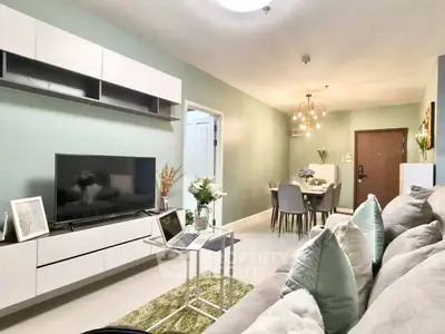 Modern living room with stylish decor and open dining area, featuring sleek furniture and ambient lighting.