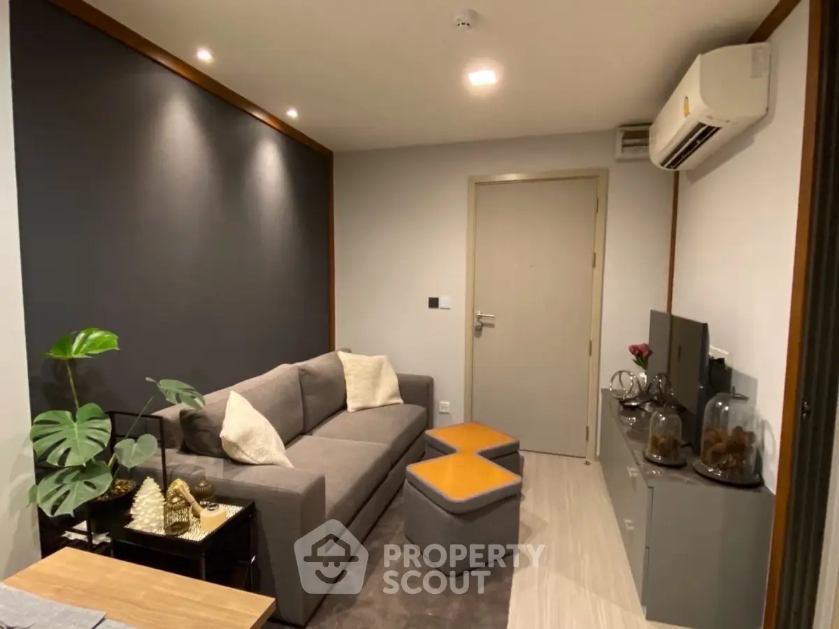 Modern living room with sleek design, featuring a cozy sofa, air conditioning, and stylish decor.