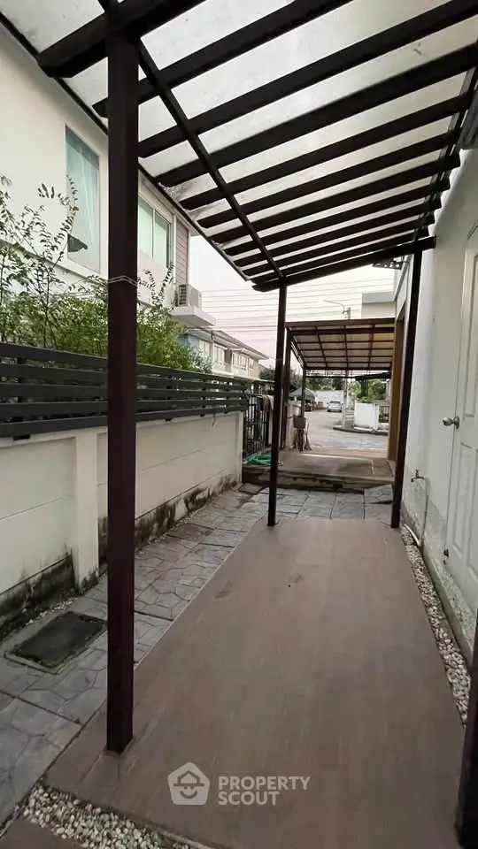 Modern townhouse exterior with covered walkway and sleek design.