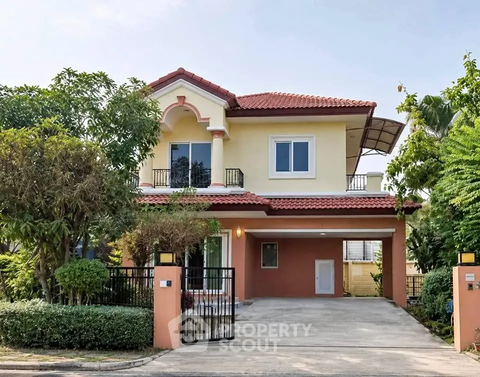 Charming two-story house with red-tiled roof and lush garden in a serene neighborhood.