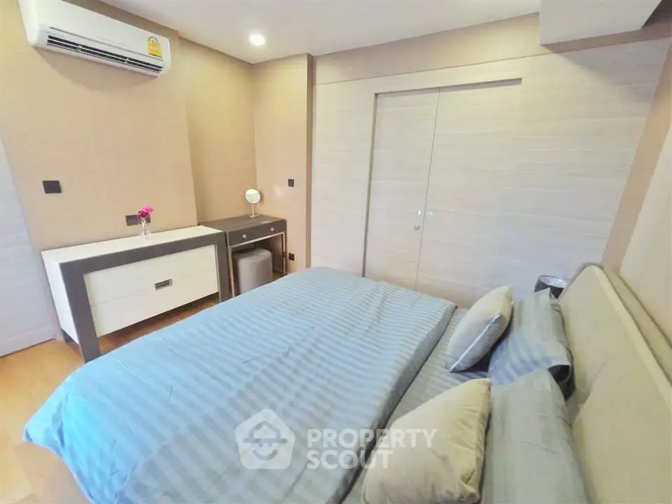Modern bedroom with stylish decor and built-in storage in a cozy apartment.