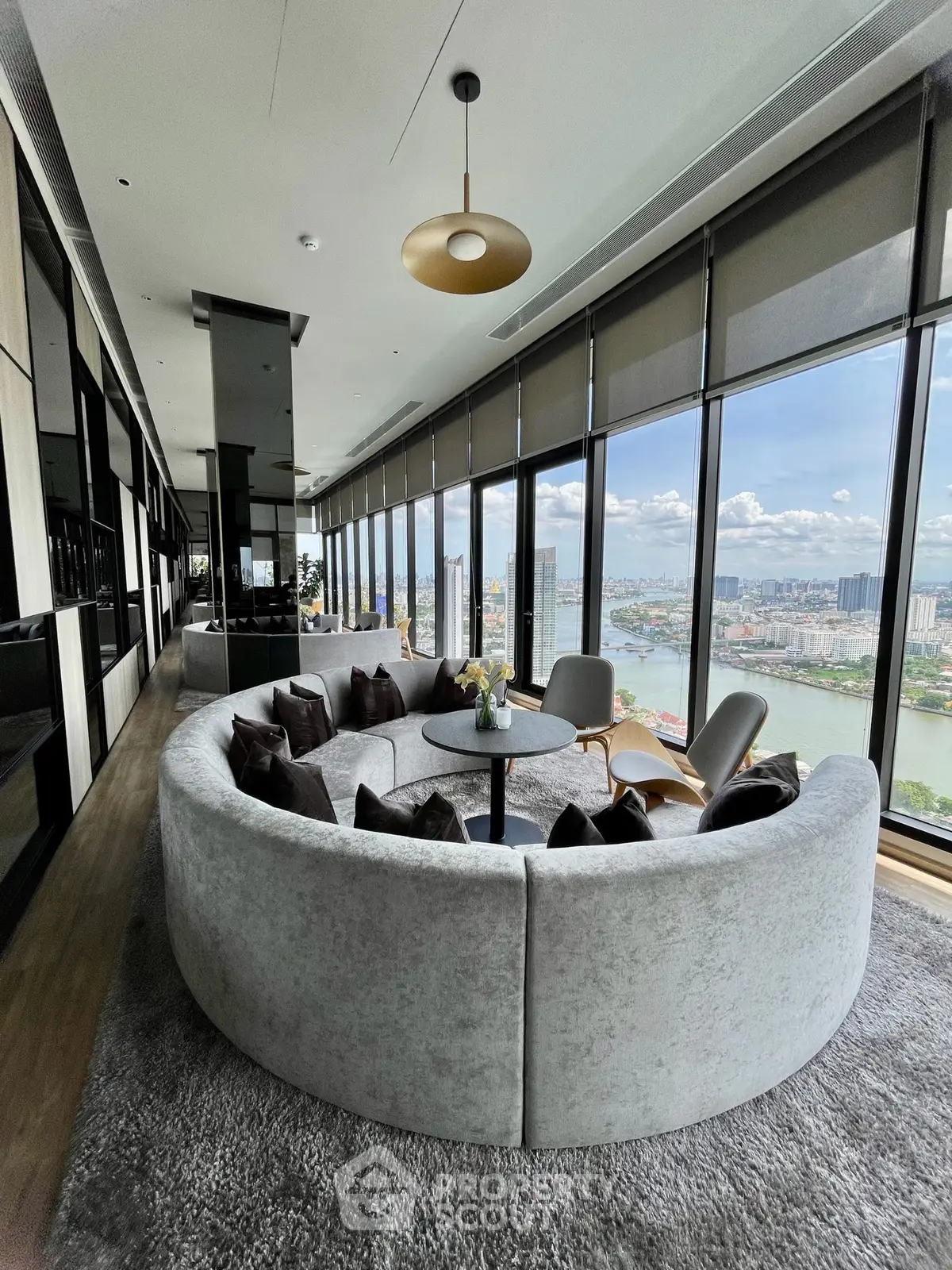 Luxurious high-rise living room with panoramic city views and elegant circular sofa.