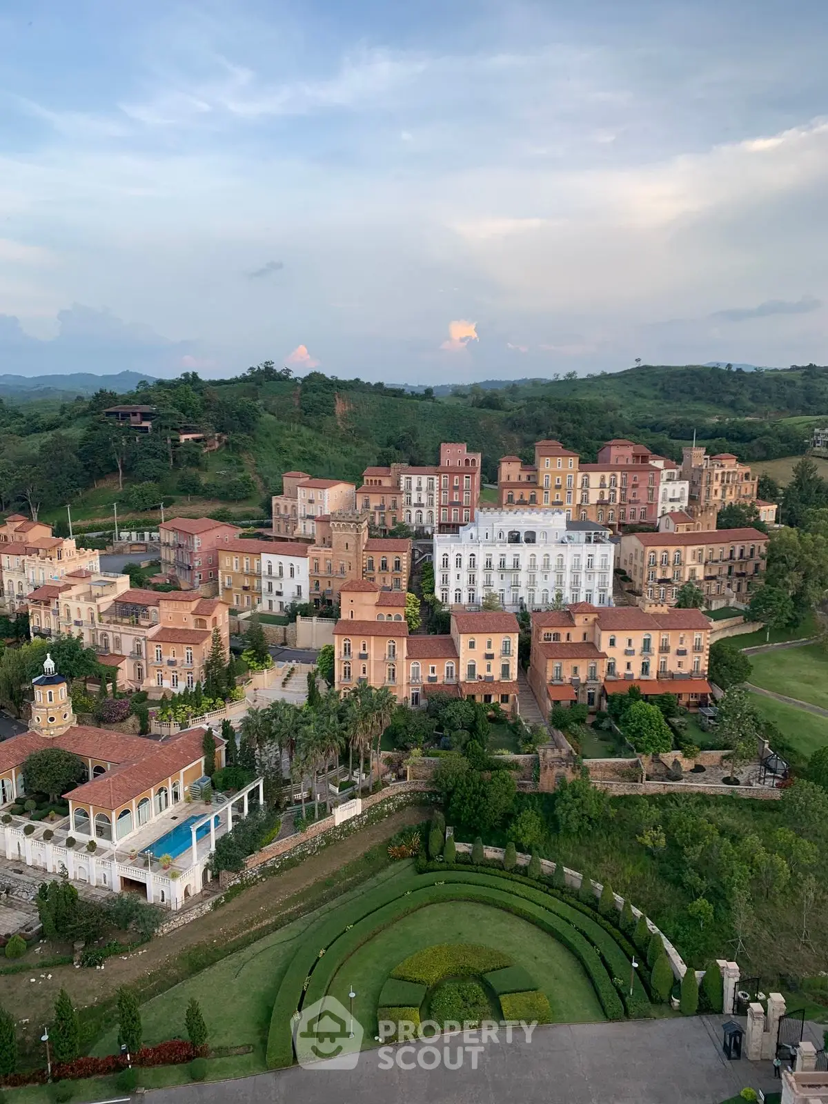 Stunning aerial view of luxurious hillside estate with elegant architecture and lush greenery.