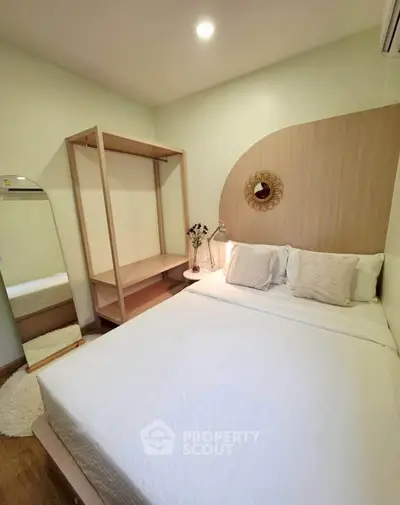 Cozy bedroom with modern decor and ample natural light, featuring a stylish wardrobe and elegant bedding.