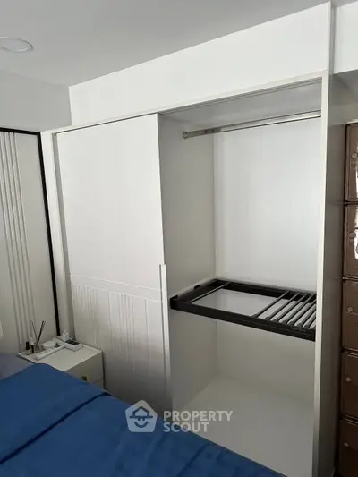 Modern bedroom with open closet and sleek design, showcasing ample storage space.